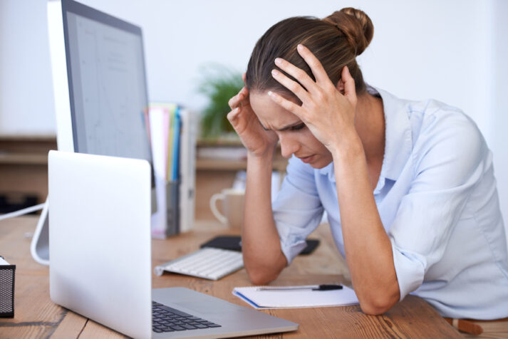 Headache, laptop problem and confused woman in office for anxiety, tax crisis and 404 pc glitch. Stress, burnout and frustrated female employee worried at computer for mistake, fail and tech disaster.